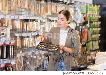 Young woman chooses tools for making sculpture 142767147