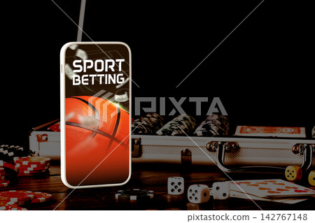 Sport betting with basketball theme on mobile device and gaming items on table 142767148