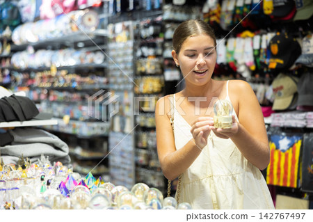 Smiling girl chooses a souvenir in store in Barcelona Smiling girl chooses a souvenir in store in Barcelona 142767497