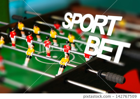 Foosball game with players in red and yellow shirts and the words sport bet in focus Foosball game with players in red and yellow shirts and the words sport bet in focus 142767509