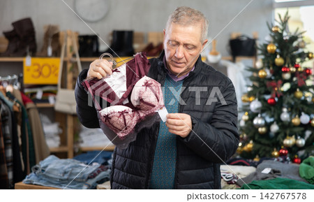 Attentive mature man choosing bra in clothing store Attentive mature man choosing bra in clothing store 142767578