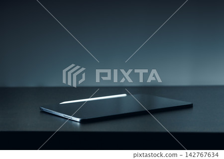 Laptop on a table in a dimly lit room during evening hours Laptop on a table in a dimly lit room during evening hours 142767634