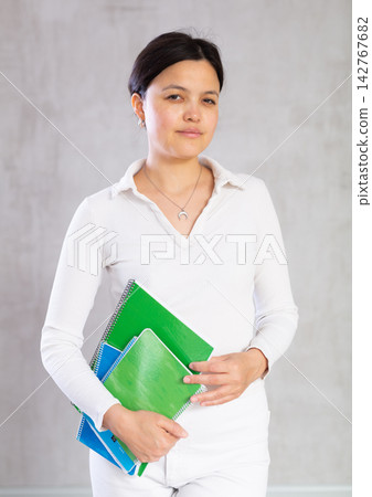 Student girl with several notebooks for writing poses in studio. Student girl with several notebooks for writing poses in studio. 142767682