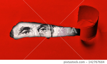 Close-up view of a dollar bill visible through a tear in red paper Close-up view of a dollar bill visible through a tear in red paper 142767684