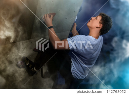 Teenage boy visitor to fitness club climbs wall for amateur sportsmen, neon light. 142768052