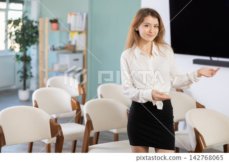 Girl office employee greets and invite visitors Girl office employee greets and invite visitors 142768065