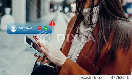 Woman receives unknown call while walking on city street during daytime Woman receives unknown call while walking on city street during daytime 142768098