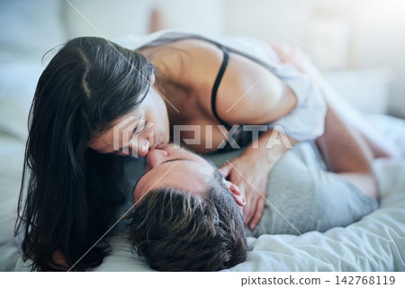 Passion, affection and couple in bed with kiss, romance and morning bonding in apartment. Relationship, man and woman in bedroom with intimate embrace, love and relax with care on weekend in home 142768119