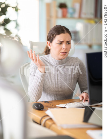 Sad young woman working on computer in office Sad young woman working on computer in office 142768507