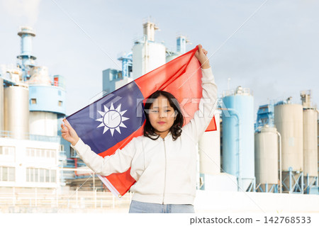 Happy young woman with flag of Taiwan against background of factory Happy young woman with flag of Taiwan against background of factory 142768533
