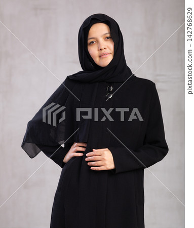 Portrait of young serious woman in hijab posing in studio Portrait of young serious woman in hijab posing in studio 142768629
