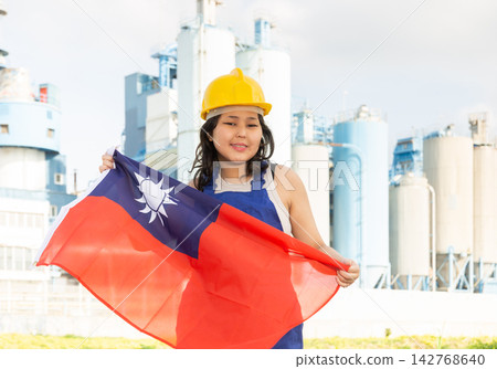Happy asian girl in work clothes and hardhat with flag of taiwan standing in front of industrial scenery Happy asian girl in work clothes and hardhat with flag of taiwan standing in front of industrial scenery 142768640