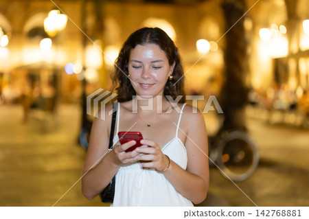 Young woman with phone in hands near restaurants Young woman with phone in hands near restaurants 142768881