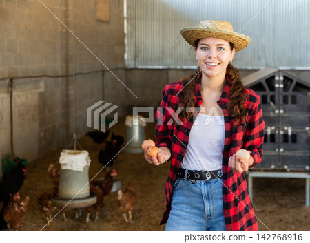 Woman farmer picking fresh eggs in henhouse Woman farmer picking fresh eggs in henhouse 142768916