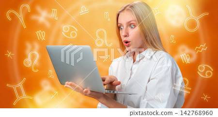 Person learns about astrology zodiac signs while using a laptop at home with zodiac symbols in the background Person learns about astrology zodiac signs while using a laptop at home with zodiac symbols in the background 142768960