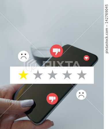 Rating system displayed on a smartphone with emojis showing different reactions and a glass of drink in the background Rating system displayed on a smartphone with emojis showing different reactions and a glass of drink in the background 142769045