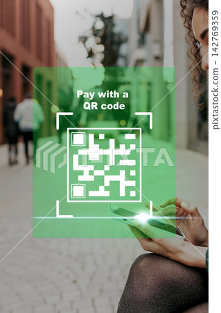 Paying online using a QR code while sitting on a street in a city Paying online using a QR code while sitting on a street in a city 142769359