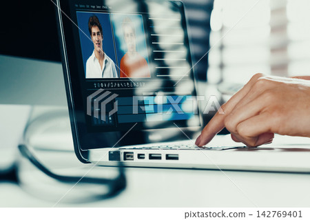 Deep fake technology used on a laptop to edit a video in a studio setting 142769401