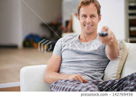 Relax, smile and man watching tv in home living room on sofa for movie, video or streaming show. Comfort, happy person and television remote control in lounge for film, news or media entertainment Relax, smile and man watching tv in home living room on sofa for movie, video or streaming show. Comfort, happy person and television remote control in lounge for film, news or media entertainment 142769456