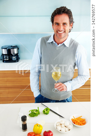Drinking wine, portrait or happy man cooking vegetables in home for healthy diet, vegan food or nutrition. Alcohol glass, smile or person in kitchen for lunch meal prep, dinner or organic salad above Drinking wine, portrait or happy man cooking vegetables in home for healthy diet, vegan food or nutrition. Alcohol glass, smile or person in kitchen for lunch meal prep, dinner or organic salad above 142769577