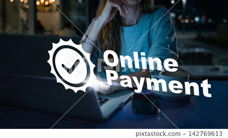 User making an online payment at a cafe during the night using a laptop and a smartphone on the table User making an online payment at a cafe during the night using a laptop and a smartphone on the table 142769613