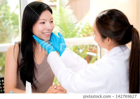 Young asian woman aesthetic doctor examining skin face of woman patient in clinical office. Young asian woman aesthetic doctor examining skin face of woman patient in clinical office. 142769627