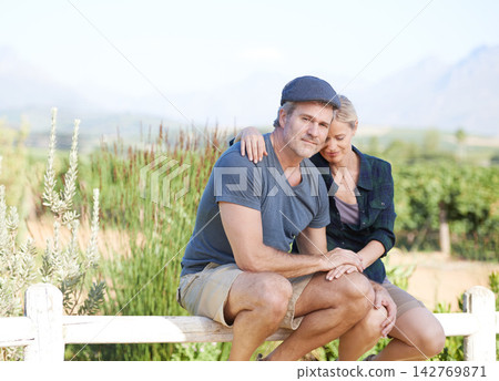 Love, portrait and couple on farm together on outdoor vacation, date or weekend trip for bonding. Travel, fence and mature man and woman sitting with sweet moment on field in countryside nature. Love, portrait and couple on farm together on outdoor vacation, date or weekend trip for bonding. Travel, fence and mature man and woman sitting with sweet moment on field in countryside nature. 142769871
