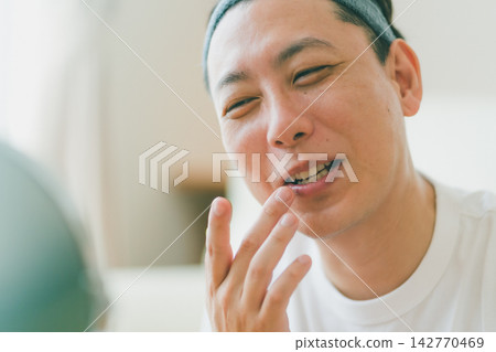 A smiling man in his 40s enjoying his lip care time. A smiling man in his 40s enjoying his lip care time. 142770469