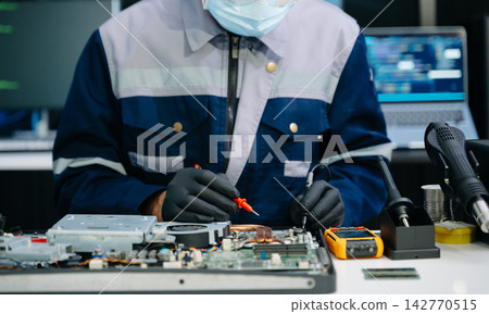 Closeup of expert soldering a green PCB board using precision tools. Ideal for electronics, circuit repair, engineering Closeup of expert soldering a green PCB board using precision tools. Ideal for electronics, circuit repair, engineering 142770515