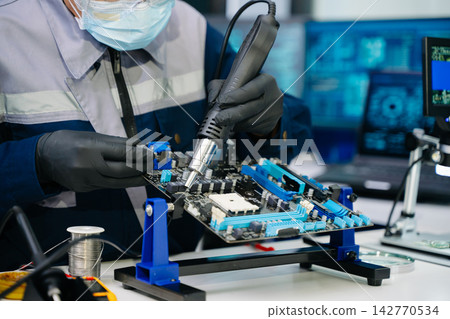 The technician is putting the CPU on the socket of the computer motherboard. electronic engineering electronic repair, electronics measuring The technician is putting the CPU on the socket of the computer motherboard. electronic engineering electronic repair, electronics measuring 142770534