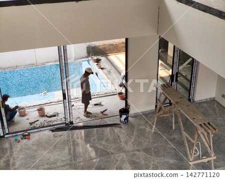 Construction workers installing sliding glass doors 142771120