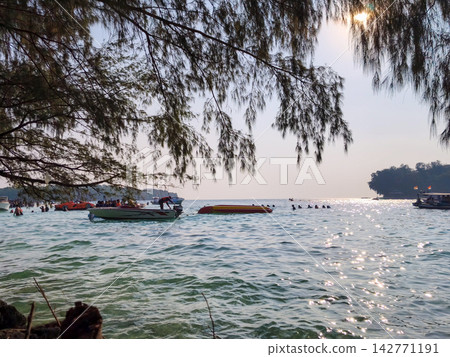 Motorboat and banana boat on clear ocean 142771191