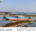Traditional wooden boat moored on low tide beach 142771213