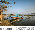 Traditional fishing boat stranded on low tide coast 142771215