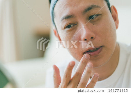 中年男子的美容時間:張開嘴巴進行唇部護理。 中年男子的美容時間:張開嘴巴進行唇部護理。 142771515