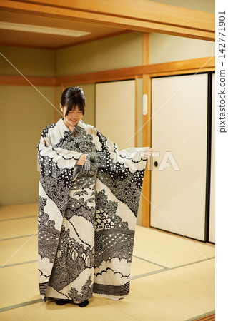 一位年輕女子試穿高品質的全染色和服，臉上洋溢著笑容。 142771901