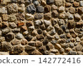 Stone wall with various shapes and colors in outdoor setting 142772416