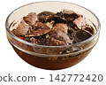 Dried wild forest mushrooms soaking in water for preparation in kitchen 142772420