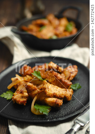 Pork stir fry cooked in a skillet with herbs on a plate Pork stir fry cooked in a skillet with herbs on a plate 142772425