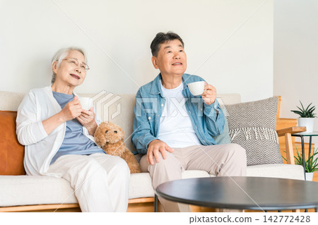一對老年夫婦和他們心愛的狗狗一起安享晚年。這是一個安全舒適的退休之家。 一對老年夫婦和他們心愛的狗狗一起安享晚年。這是一個安全舒適的退休之家。 142772428