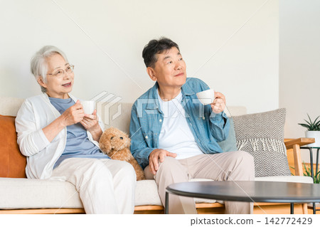 一對老年夫婦和他們心愛的狗狗一起安享晚年。這是一個安全舒適的退休之家。 一對老年夫婦和他們心愛的狗狗一起安享晚年。這是一個安全舒適的退休之家。 142772429