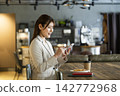 A woman using a smartphone in a cafe 142772968