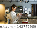 A woman using a smartphone in a cafe 142772969