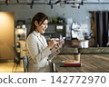 A woman using a smartphone in a cafe 142772970