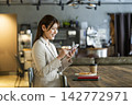 A woman using a smartphone in a cafe 142772971
