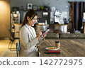 A woman using a smartphone in a cafe 142772975