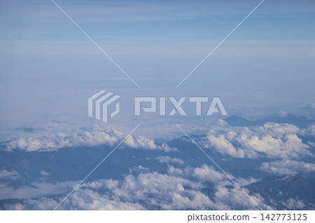 Cloud opening revealing mountain landscape below Cloud opening revealing mountain landscape below 142773125