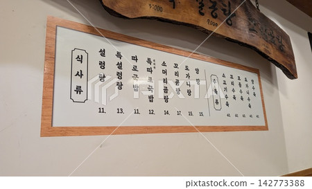 韓國餐廳牆上展示著一份用韓文書寫的菜單。 韓國餐廳牆上展示著一份用韓文書寫的菜單。 142773388