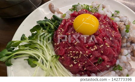 Yukhoe topped with egg yolk, eaten at Gwangjang Market in South Korea Yukhoe topped with egg yolk, eaten at Gwangjang Market in South Korea 142773396
