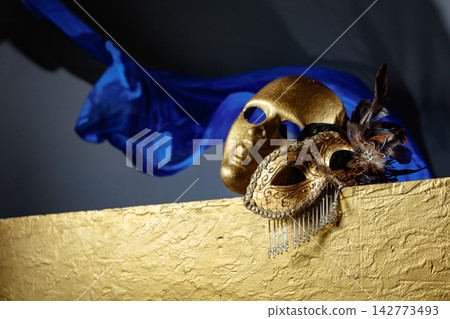 Golden carnival masks on a gold background. 142773493